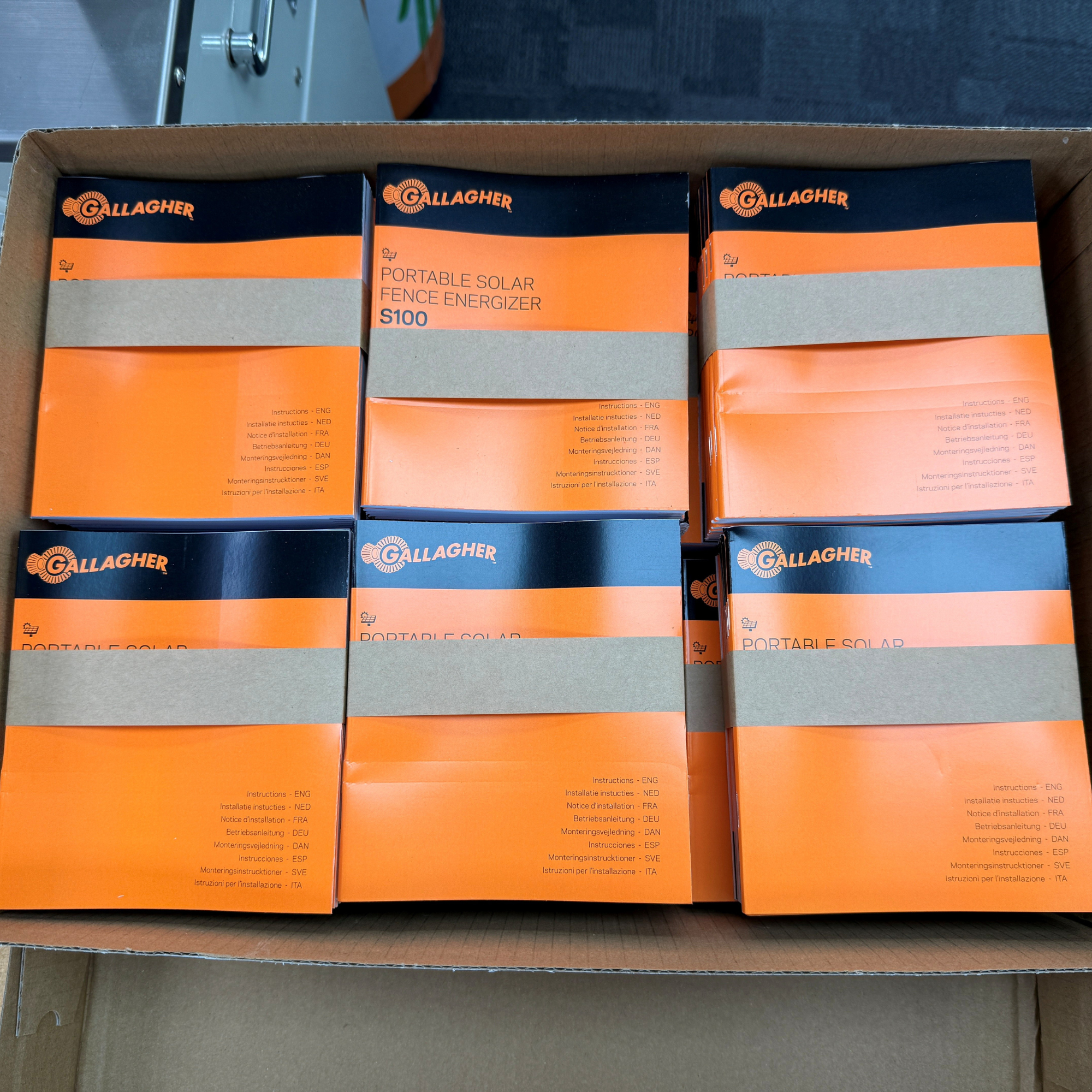 Image of a box of portable solar fence energizer user guides printed at the Gallagher Print House