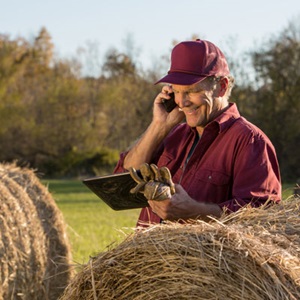 Farmer-using-tablet-and-talking-on-mobile-phone
